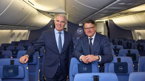 Zwei Männer stehen im Passagierbereich des Flugzeugs.